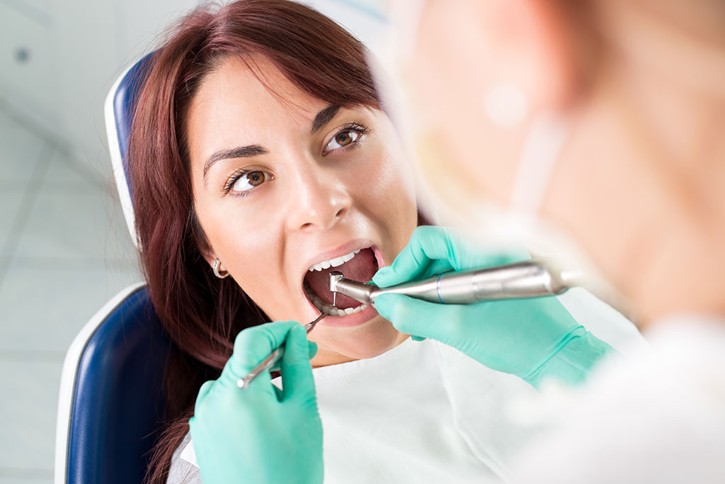 Photo of a woman having root_canal-dental-treatment-with-dental-drill