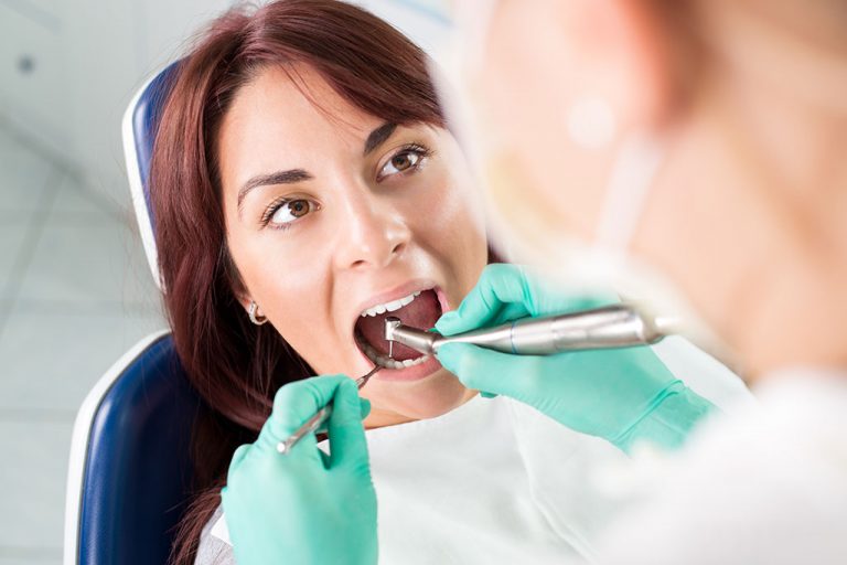 Photo of a woman having root_canal-dental-treatment-with-dental-drill